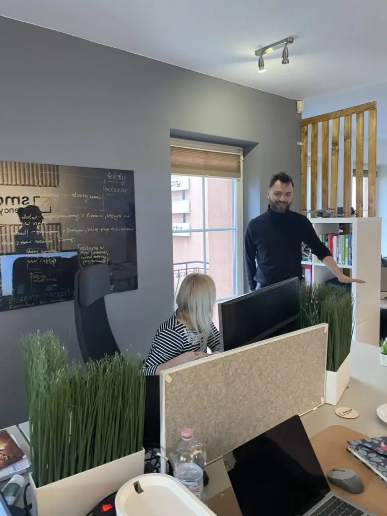 Nowoczesny biurowy open space z zespołem pracującym przy komputerach w SMART Agency