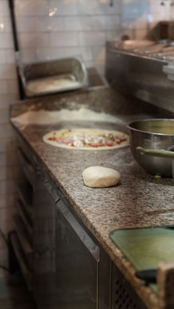 Przygotowanie pizzy na kuchni - zdjęcie procesu z dnia zdjęciowego